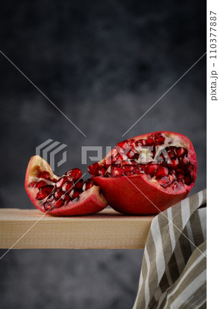 Pomegranate. Parts of a whole Pomegranate on a dark background. Pomegranate. Parts of a whole Pomegranate on a dark background. 110377887