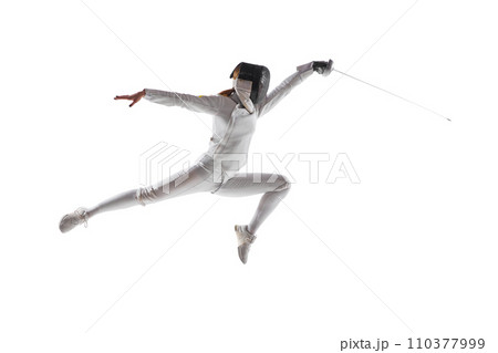 Artistry of combat. Female fencer gracefully executes complex fencing maneuver in action against white studio background. 110377999