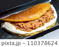Venezuelan Cachapa with Pulled Meat on Black Plate in Restaurant 110378624