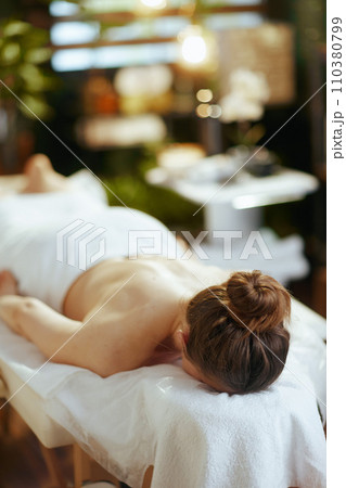 relaxed modern woman in spa salon laying on massage table relaxed modern woman in spa salon laying on massage table 110380799
