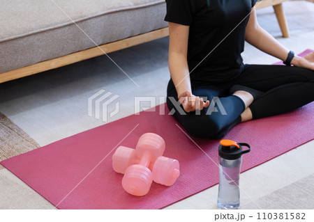 Young woman practicing lotus asana in yoga studio. Padmasana pose 110381582