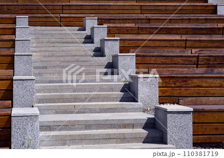 wooden benches along the granite stairs going up to the street theater on a sunny summer day, nobody. 110381719