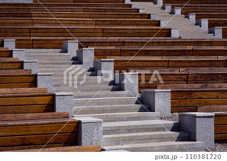 granite stairs between empty wooden benches at street theater on a sunny summer day, nobody. granite stairs between empty wooden benches at street theater on a sunny summer day, nobody. 110381720