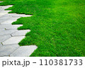pavement with concrete tiles honeycomb pattern and green lawn lit by sunlight close-up, nobody. 110381733
