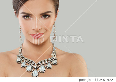 Perfect jewelry model woman with dark brown hair and shiny fresh skin wearing diamond earring  110381972