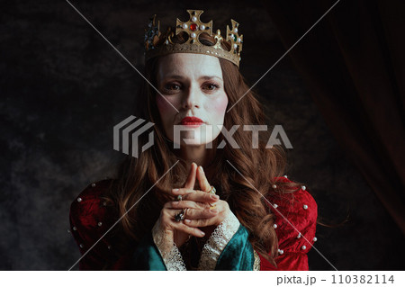 medieval queen in red dress with white makeup and crown medieval queen in red dress with white makeup and crown 110382114