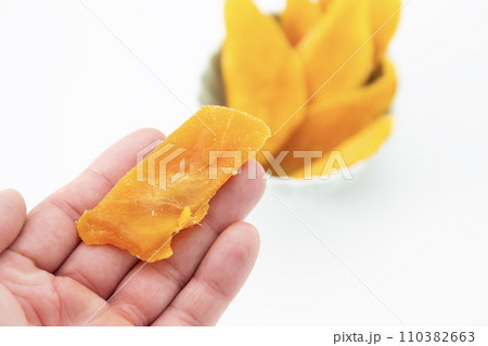 ドライマンゴーを持つ男性手元 110382663