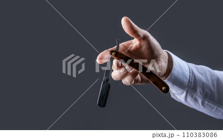 hand hold hairsdresser razor blade in studio. photo of hairsdresser blade in hand. hand hold hairsdresser razor blade in studio. photo of hairsdresser blade in hand. 110383086