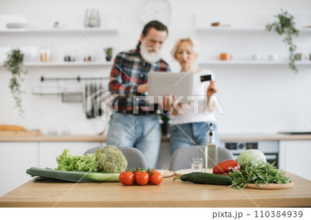 Focus on the vegetables and herbs lying on the table. 110384939
