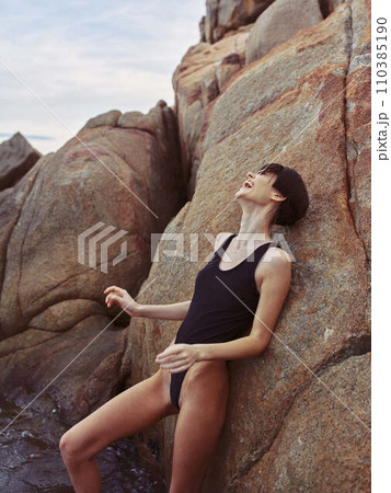 Summertime Seduction: A Beautiful Brunette Woman Posing Sensually in Sexy Swimwear on a Tropical Beach Summertime Seduction: A Beautiful Brunette Woman Posing Sensually in Sexy Swimwear on a Tropical Beach 110385190