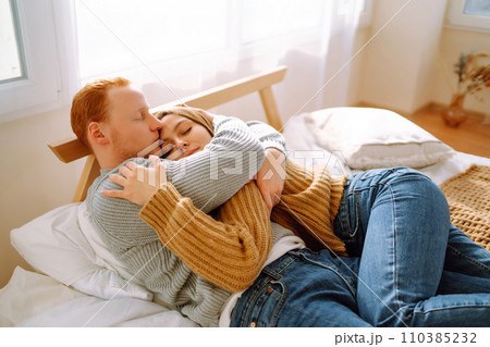 Couple in love relaxing at home on bed while they hug each other. Valentine's Day, holiday concept. 110385232