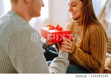 Valentine's Day concept. Exchange of gifts. Young couple at home celebrating Valentine's Day. 110385246