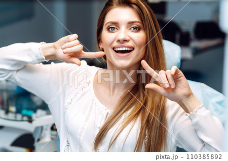 Young woman at the dentist's chair during a dental procedure. Overview of dental caries prevention. 110385892