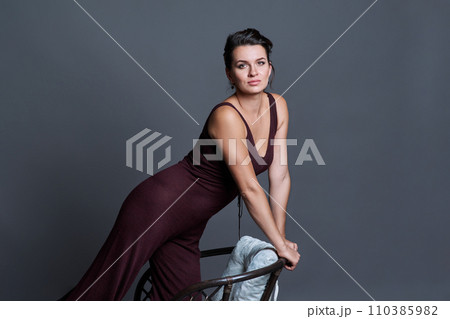 Fashionable young woman posing on dark gray studio background 110385982