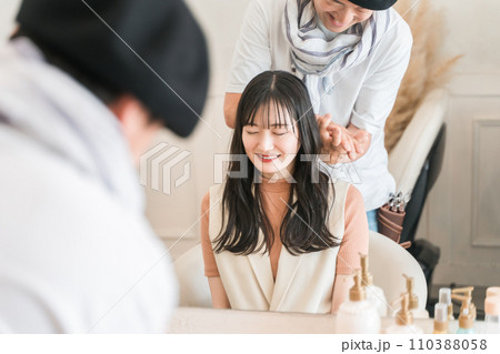 美容室・ヘアサロンで肩や首をマッサージをする美容師と顧客の女性 美容室・ヘアサロンで肩や首をマッサージをする美容師と顧客の女性 110388058