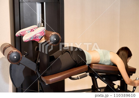 レッグカールで足を鍛える女性 レッグカールで足を鍛える女性 110389610