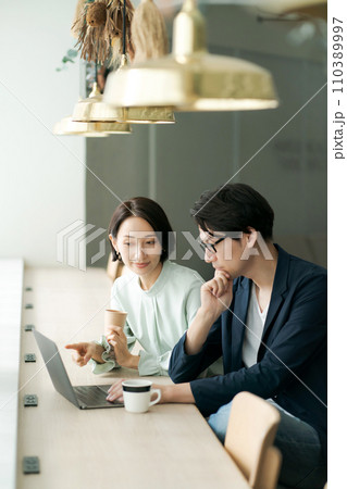 カフェで打ち合わせをするカップル カフェで打ち合わせをするカップル 110389997