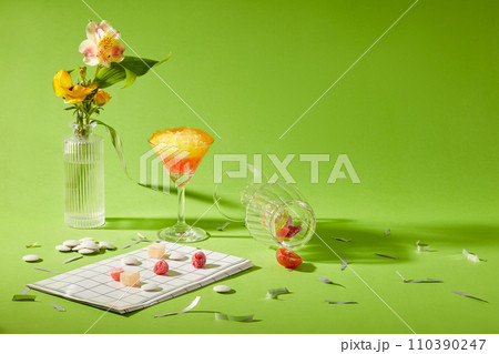 Creative scene for design and advertising product with holiday decoration concept. A cup of smoothie with flowers vase and some snacks decorated on a green background. Front view and copy space Creative scene for design and advertising product with holiday decoration concept. A cup of smoothie with flowers vase and some snacks decorated on a green background. Front view and copy space 110390247