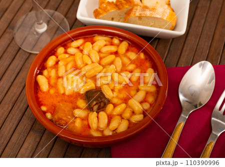Beans stew Fabada with pork, morcilla and chorizo in clay bowl 110390996