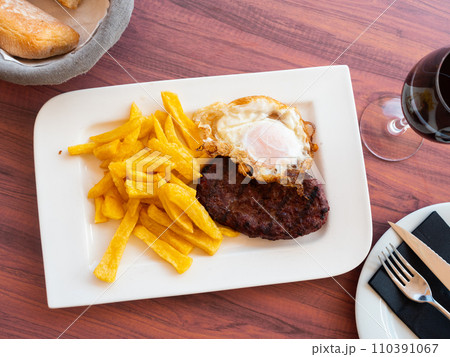 Picture of fried pork with fried eggs and french fries at plate Picture of fried pork with fried eggs and french fries at plate 110391067