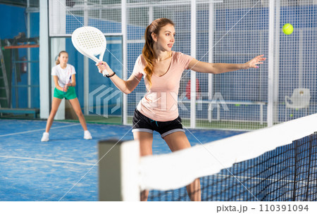 Woman playing padel in court Woman playing padel in court 110391094