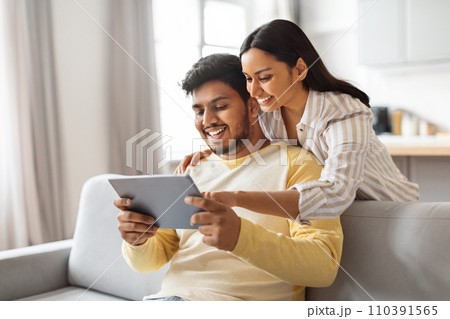 Young Happy Indian Spouses Using Digital Tablet At Home 110391565