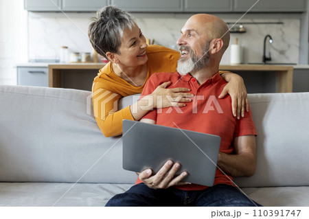 Happy Senior Couple With Laptop Having Fun Together At Home Happy Senior Couple With Laptop Having Fun Together At Home 110391747