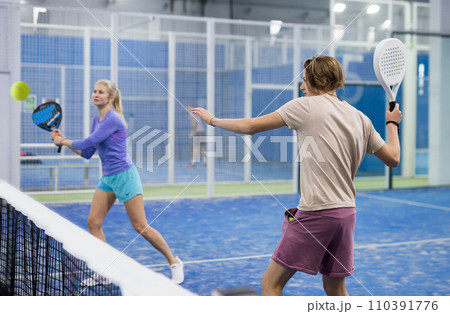 Teenage man playing paddle tennis on padel court Teenage man playing paddle tennis on padel court 110391776