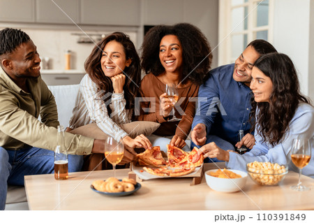 Diverse friends gathering for home dinner with beer and pizza 110391849