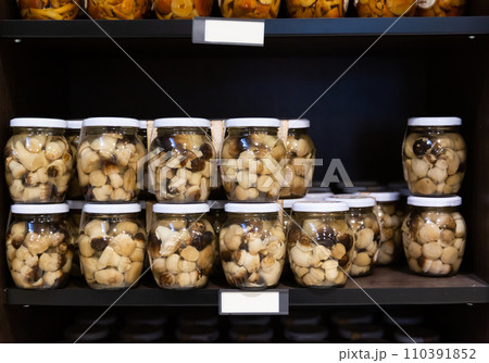 Pickled fredolics mushrooms in glass jars on counter 110391852