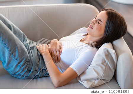 Lady suffering from abdominal discomfort, having painful menstruation cramps indoors 110391892