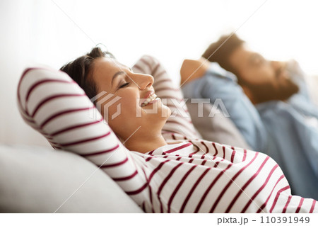 Closeup of lovely indian couple chilling on couch at home Closeup of lovely indian couple chilling on couch at home 110391949