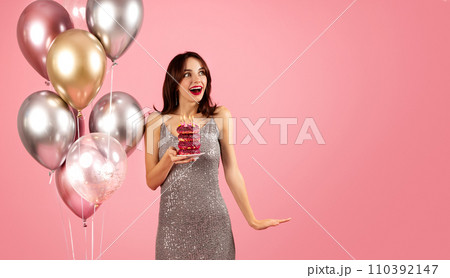 An ecstatic woman with brown hair and red lipstick, wearing a sparkling sequined dress 110392147