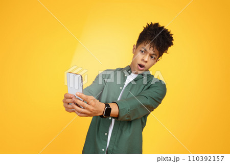 Shocked young black guy looking at smartphone screen Shocked young black guy looking at smartphone screen 110392157