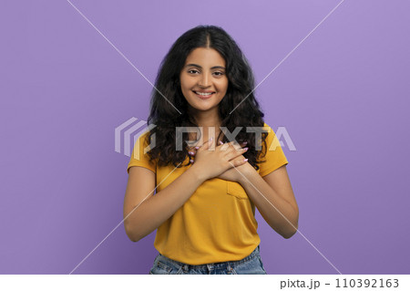 Happy young eastern lady holding hands on chest Happy young eastern lady holding hands on chest 110392163