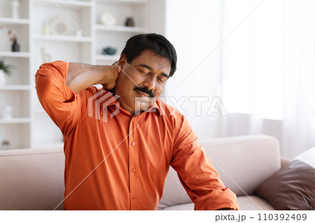 Suffering middle aged indian man feeling neck pain 110392409