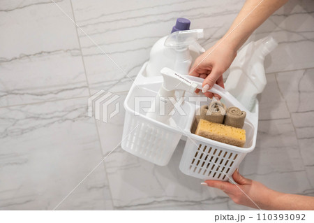 Female hands holding plastic container with chemical detergent for bathroom laundry cleaning 110393092