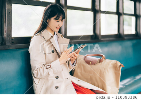 電車でスマホを見る女性 110393386
