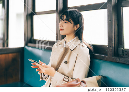 電車でスマホを見る女性 110393387