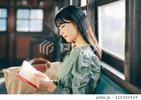 電車で読書をする女性 110393424
