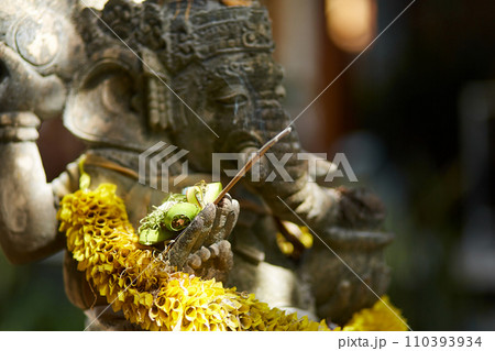 Sculpture of a temple with flowers and incense for ritual offerings on the popular tourist island of Bali. Sculpture of a temple with flowers and incense for ritual offerings on the popular tourist island of Bali. 110393934