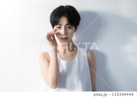不安げな表情で視線を落とす黒髪ショートヘアの女性バストアップ 110394449