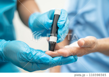 Doctor check diabetes from finger blood sugar level with finger lancet. 110396565