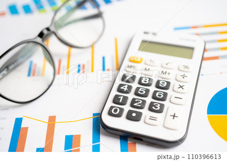 Eyeglass with calculator on chart graph paper. Finance, account, statistic, investment data economy, stock exchange business. Eyeglass with calculator on chart graph paper. Finance, account, statistic, investment data economy, stock exchange business. 110396613