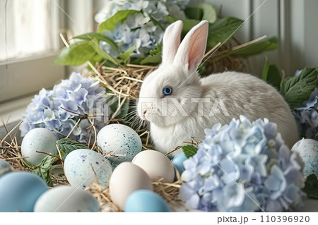 White Bunny with blue eyes surrounded by pastel colored eggs and blooming hydrangeas 110396920