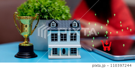 House model, trophy and smartphone. Real estate investment and home loan concept. House model, trophy and smartphone. Real estate investment and home loan concept. 110397244