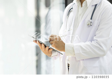 Close up of doctor hands using digital tablet at clinic. 110398035