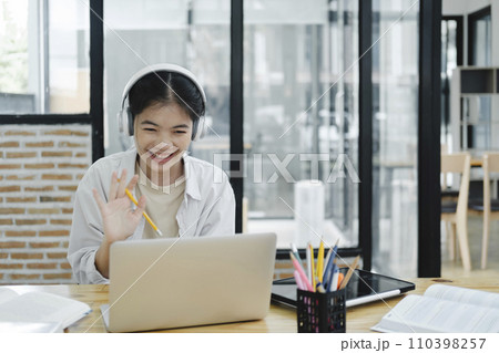 Young woman waving to his colleague and explaining and discuss her opinions during the online meeting. Young woman waving to his colleague and explaining and discuss her opinions during the online meeting. 110398257