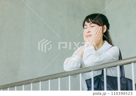 階段の踊り場で手すりに頬杖をつくビジネスウーマン 110398523