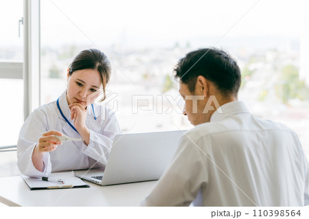 体温計で体温を確認する女性医師・医者と男性患者（発熱・風邪・体温） 110398564